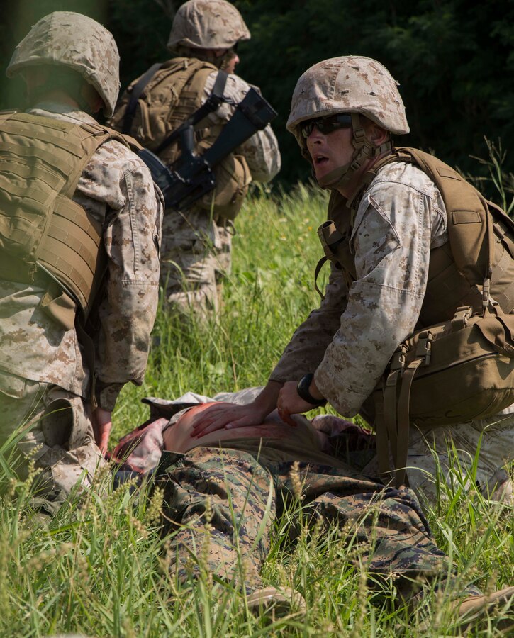 Petty Officer 2nd Class Joshua Rogers, right, from Martin, Georgia, responds to a simulated wounded enemy during a medical evacuation drill Sept. 30 at the Kin Blue Training Area. Rogers was part of the quick reaction force that gained control over two mock enemy positions. Marines and sailors are taught to provide first aid to enemy personnel as well as their own forces. Rogers is with 3rd Medical Battalion, 3rd Marine Logistics Group, III Marine Expeditionary Force. (U.S. Marine Corps photo by Lance Cpl. Rebecca Elmy/Released)