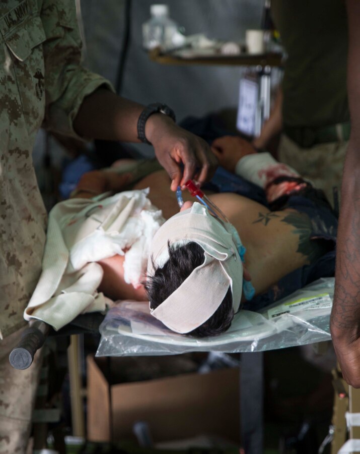 A service member acts as a casualty during a simulated medical evacuation drill Sept. 30 at the Kin Blue Training Area. The training exercise was spread out over the course of five days and involved corpsman and Marines responding to different medical scenarios they might encounter in the field. The casualty actors helped to add realism to the exercise, according to U.S. Navy Capt. Michele Hancock, from Waynesburg, Pennsylvania. “They were crying out in pain and asking where their buddies were,” said Hancock. “It causes the personnel to reassure the patient while they’re still assessing them and providing medical treatment.” The corpsman and Marines are with 3rd Medical Battalion, 3rd Marine Logistics Group, III Marine Expeditionary Force. (U.S. Marine Corps photo by Lance Cpl. Rebecca Elmy/Released)