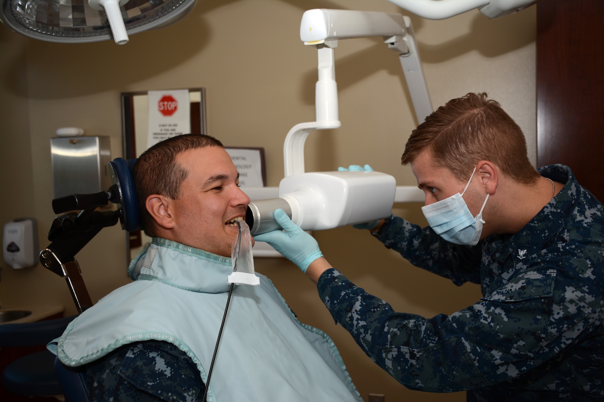 Navy Dental Assistant Petty Officer 3rd Class Donald Kern positions the digital x-ray camera on his patient on Oct. 4, 2014 at Tinker Air Force Base, to take bitewing
x-rays as part of the annual dental exam.  The Navy reserve dental team
serves approximately 30 patients a month.  (U.S. Air Force photo/Staff Sgt. Lauren Gleason)
