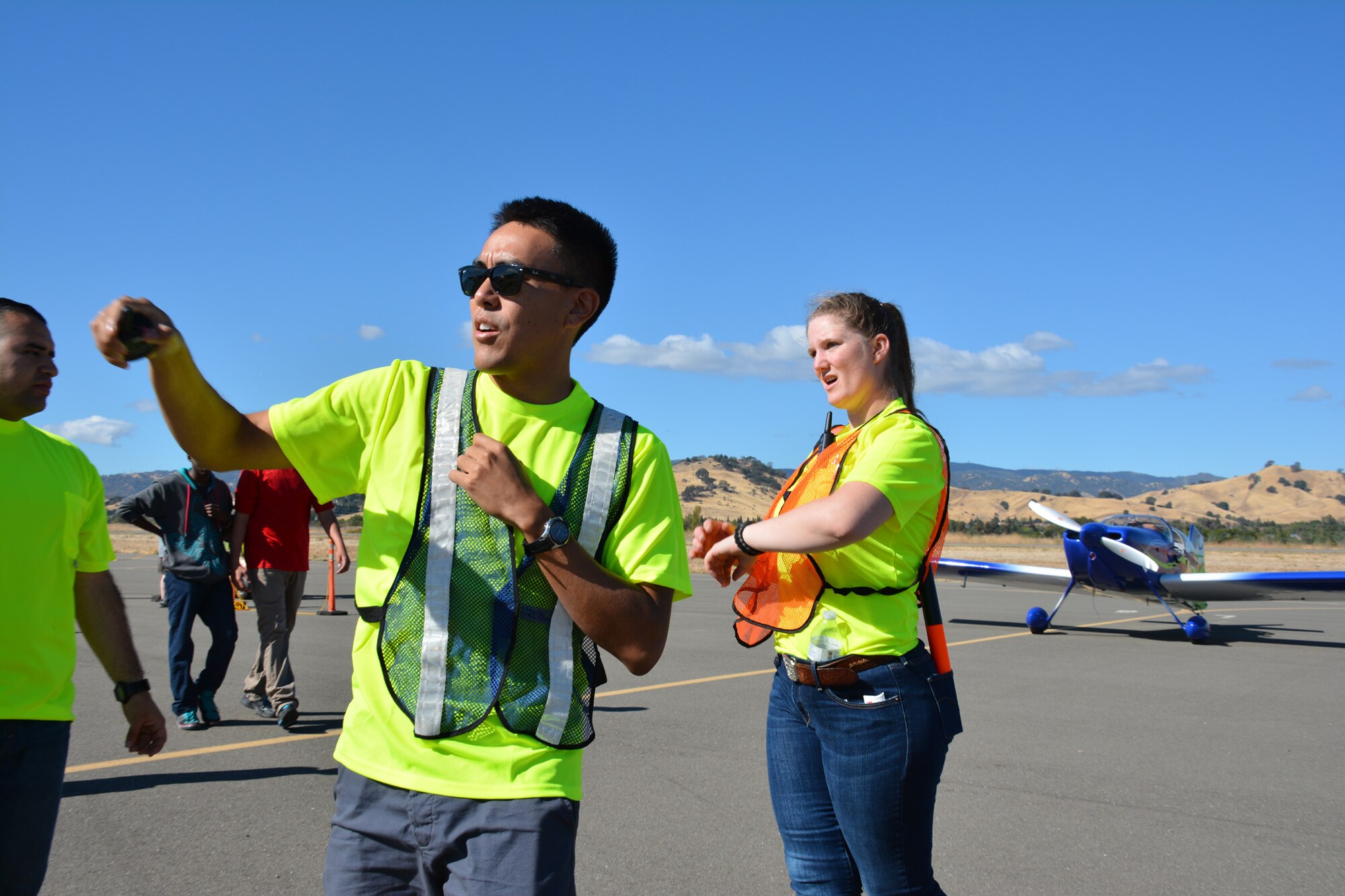 TRAVIS AIR FORCE BASE, Calif. -- Senior Airman Melanie Ivey works with other members of the Air Force Reserve's 349th Air Mobility Wing to coordinate aircraft parking Oct. 18, 2014, during the 9th Annual "Mustangs and More" aircraft and car show at the Nut Tree Airport in Vacaville, Calif. This year's event hosted more than 40 vintage aircraft as well as classic and new Ford Mustangs and other muscle cars. All of the proceeds from ticket sales went to support the Travis Air Force Base Heritage Center and the maintenance of display aircraft there. (U.S. Air Force photo/2nd Lt. Stephen J. Collier) 
