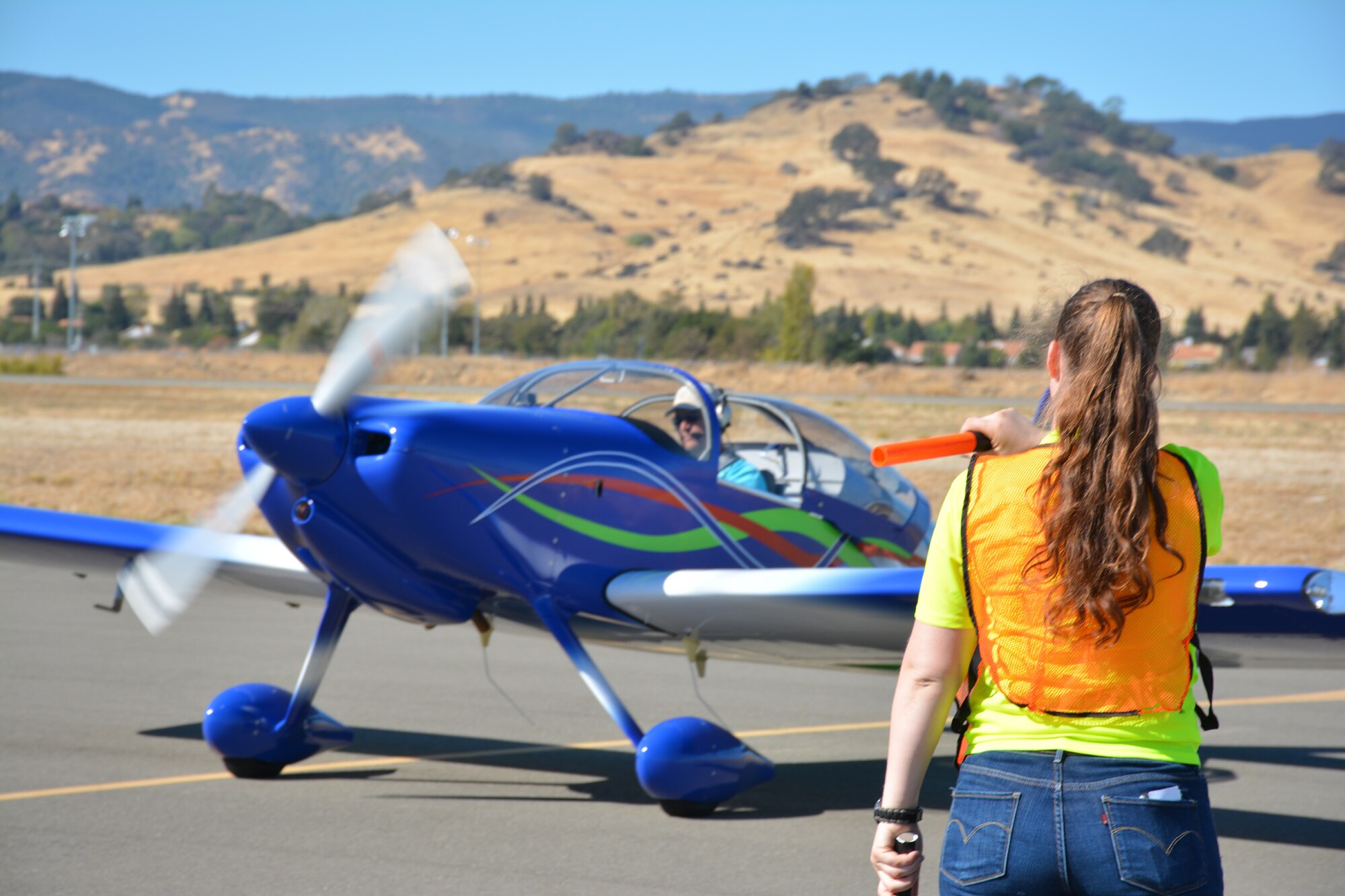 TRAVIS AIR FORCE BASE, Calif. -- Senior Airman Melanie Ivey works with other members of the Air Force Reserve's 349th Air Mobility Wing to coordinate aircraft parking Oct. 18, 2014, during the 9th Annual "Mustangs and More" aircraft and car show at the Nut Tree Airport in Vacaville, Calif. This year's event hosted more than 40 vintage aircraft as well as classic and new Ford Mustangs and other muscle cars. All of the proceeds from ticket sales went to support the Travis Air Force Base Heritage Center and the maintenance of display aircraft there. (U.S. Air Force photo/2nd Lt. Stephen J. Collier) 
