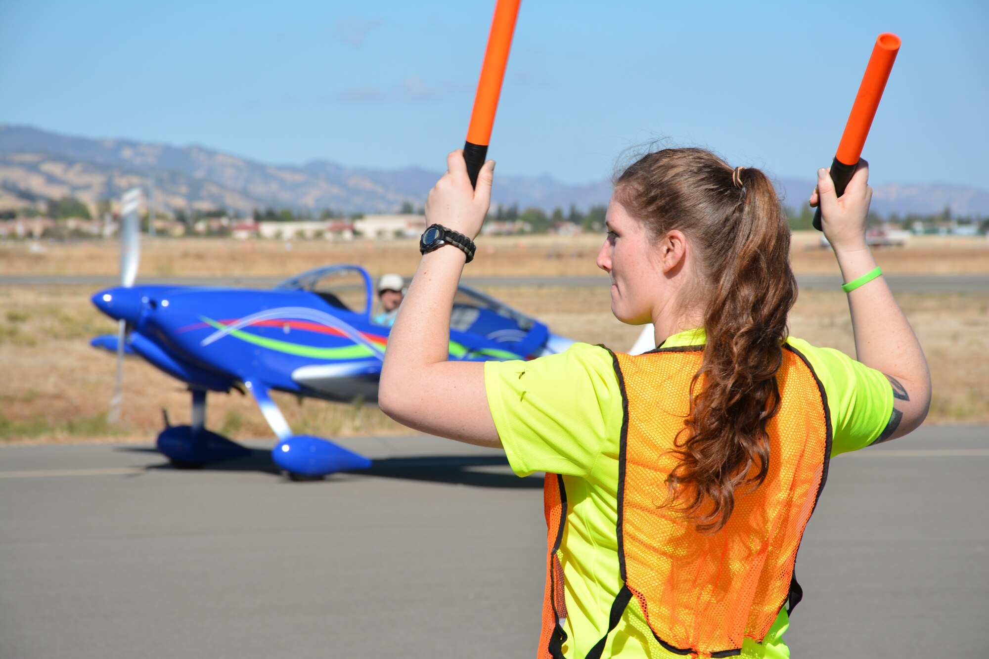 TRAVIS AIR FORCE BASE, Calif. -- Senior Airman Melanie Ivey works with other members of the Air Force Reserve's 349th Air Mobility Wing to coordinate aircraft parking Oct. 18, 2014, during the 9th Annual "Mustangs and More" aircraft and car show at the Nut Tree Airport in Vacaville, Calif. This year's event hosted more than 40 vintage aircraft as well as classic and new Ford Mustangs and other muscle cars. All of the proceeds from ticket sales went to support the Travis Air Force Base Heritage Center and the maintenance of display aircraft there. (U.S. Air Force photo/2nd Lt. Stephen J. Collier) 
