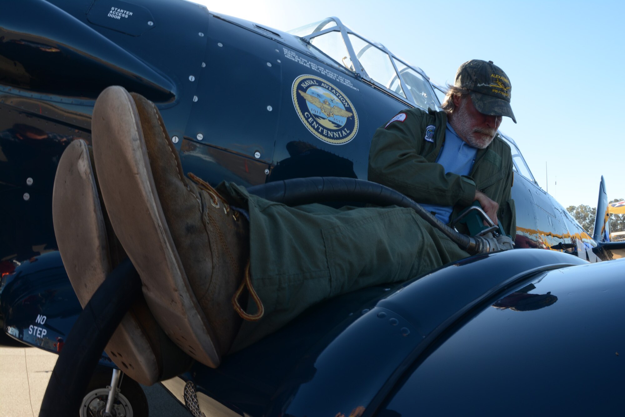 TRAVIS AIR FORCE BASE, Calif. -- Randy Bradley, a member of the Vulture Row Aviation Team, fuels a World War II-era Navy fighter aircraft Oct. 18. 2014 during the 9th Annual "Mustangs and More" aircraft and car show at the Nut Tree Airport in Vacaville, Calif. This year's event hosted more than 40 vintage aircraft  as well as classic and new Ford Mustangs and other muscle cars. All of the proceeds from ticket sales went to support the Travis Air Force Base Heritage Center and the maintenance of display aircraft there. (U.S. Air Force photo/2nd Lt. Stephen J. Collier)
