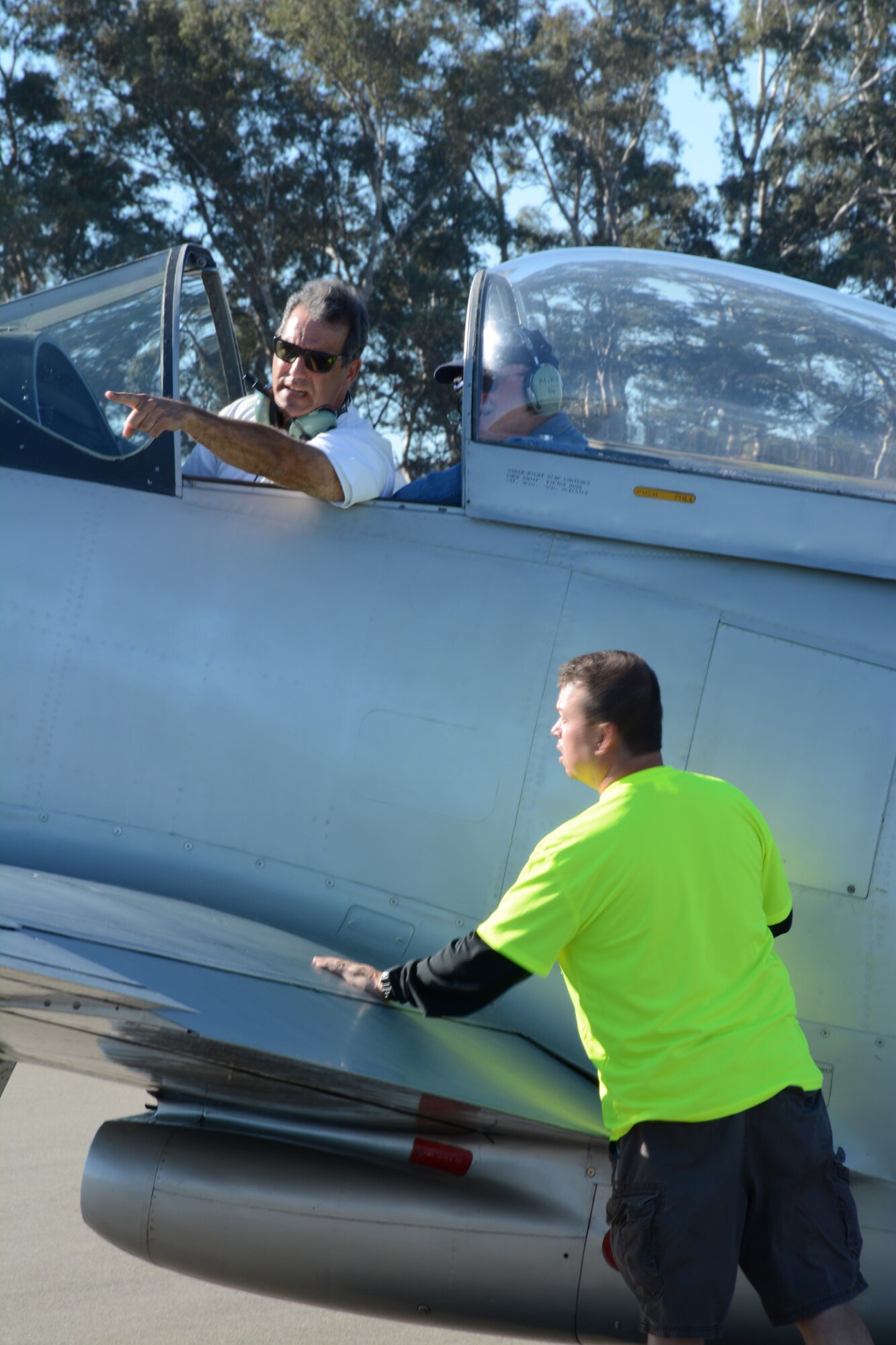 TRAVIS AIR FORCE BASE, Calif. -- Senior Master Sgt. James Grant, 312th Airlift Squadron, coordinates a parking spot with the pilot of a World War II-era P-51 Mustang Oct. 18, 2014, during the 9th Annual "Mustangs and More" aircraft and car show at the Nut Tree Airport in Vacaville, Calif. Members of the Air Force Reserve's 349th Air Mobility Wing volunteered to support the event in which all of the proceeds from ticket sales went to support the Travis Air Force Base Heritage Center and the maintenance of display aircraft there. This year's event hosted more than 40 vintage aircraft  as well as classic and new Ford Mustangs and other muscle cars. Grant is assigned to the 312th Airlift Squadron. (U.S. Air Force photo/2nd Lt. Stephen J. Collier) 