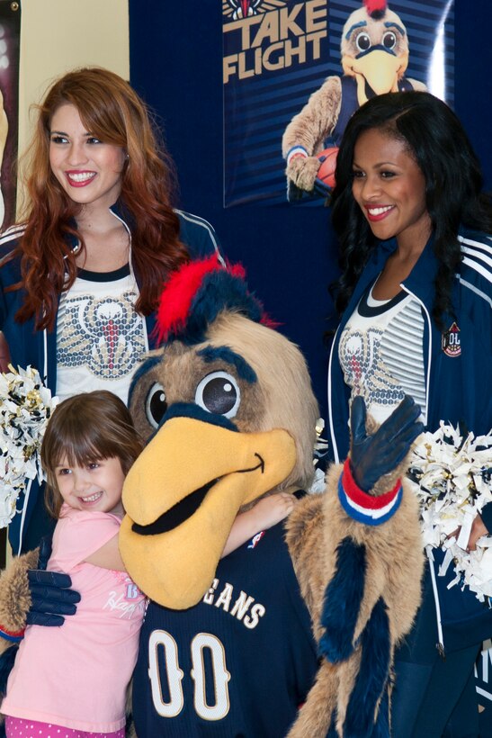 A girl hugs Pierre the Pelican while posing with two members of the New Orleans Pelicans dance team during their visit to Barksdale Air Force Base, La., Oct. 22, 2014. Pierre is the mascot for the National Basketball Association team who is in Bossier City, La., to play a preseason game against the Dallas Mavericks. (U.S. Air Force photo by Master Sgt. Dachelle Melville/Released)