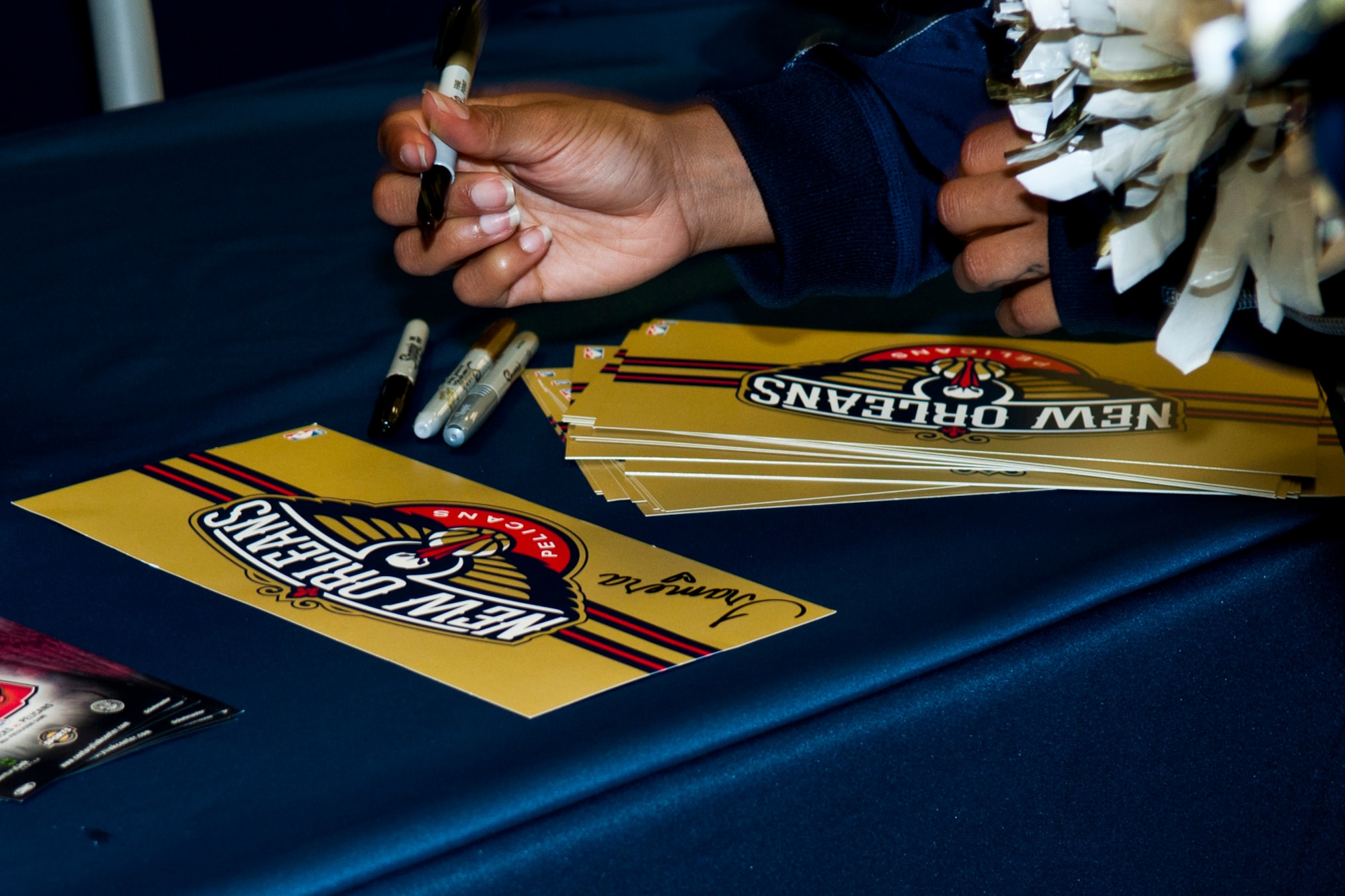 New Orleans Pelicans dance team members sign autographs for patrons at the Army & Air Force Base Exchange at Barksdale Air Force Base, La., Oct. 22, 2014. Members of the dance team along with the mascot of the National Basketball Association team took time out of their schedule to visit while in Bossier City, La., for a preseason game against the Dallas Mavericks. (U.S. Air Force photo by Master Sgt. Dachelle Melville/Released)