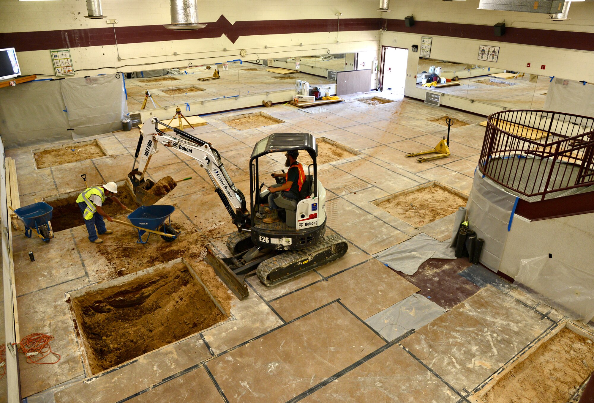 Workers at the Gerrity Fitness and Sports Center scoop dirt out of holes, which will soon be filled with posts to support a new mezzanine. The second floor is one of several renovations underway. Other plans include a 1,600 square foot addition to the back of the gym, new rubber flooring and a new roof. (Air Force photo by Kelly White)