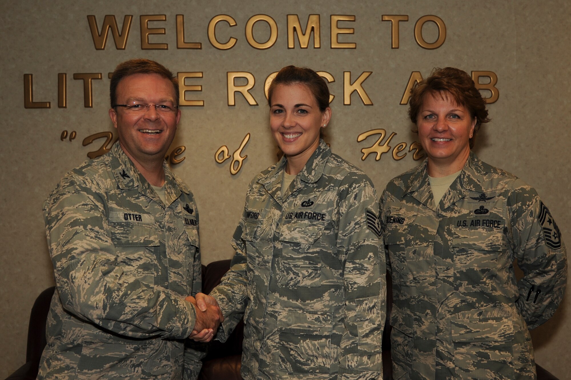 Col. William Otter, 19th Airlift Wing vice commander, and Chief Master Sgt. Rhonda Buening, 19th AW command chief, congratulate Tech. Sgt. April Stanford, 19th Operations Support Squadron weather flight noncommissioned officer in charge, for her selection as Combat Airlifter of the Week Oct. 20, 2014, at Little Rock Air Force Base, Ark. Stanford, an Arlington, Texas native, coordinates mission weather support for three wings by issuing watches, warnings and advisories for the base and two drop zones. (U.S. Air Force photo by Airman 1st Class Harry Brexel)  
