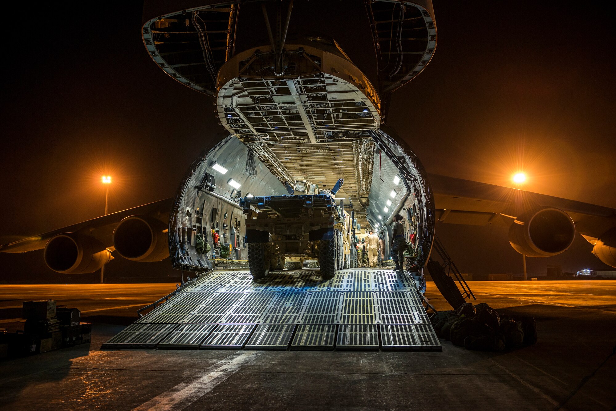 Airmen from the 9th Airlift Squadron and 455th Expeditionary Aerial Port Squadron with Marines from the Marine Expeditionary Brigade load vehicles into a C-5M Super Galaxy Oct. 6, 2014, at Camp Bastion, Afghanistan. Airmen and Marines loaded more than 266,000 pounds of cargo onto the C-5M as part of retrograde operations in Afghanistan. During this mission, the crew reached more than 11 million pounds of cargo transported in a 50-day period. (U.S. Air Force photo by Staff Sgt. Jeremy Bowcock)