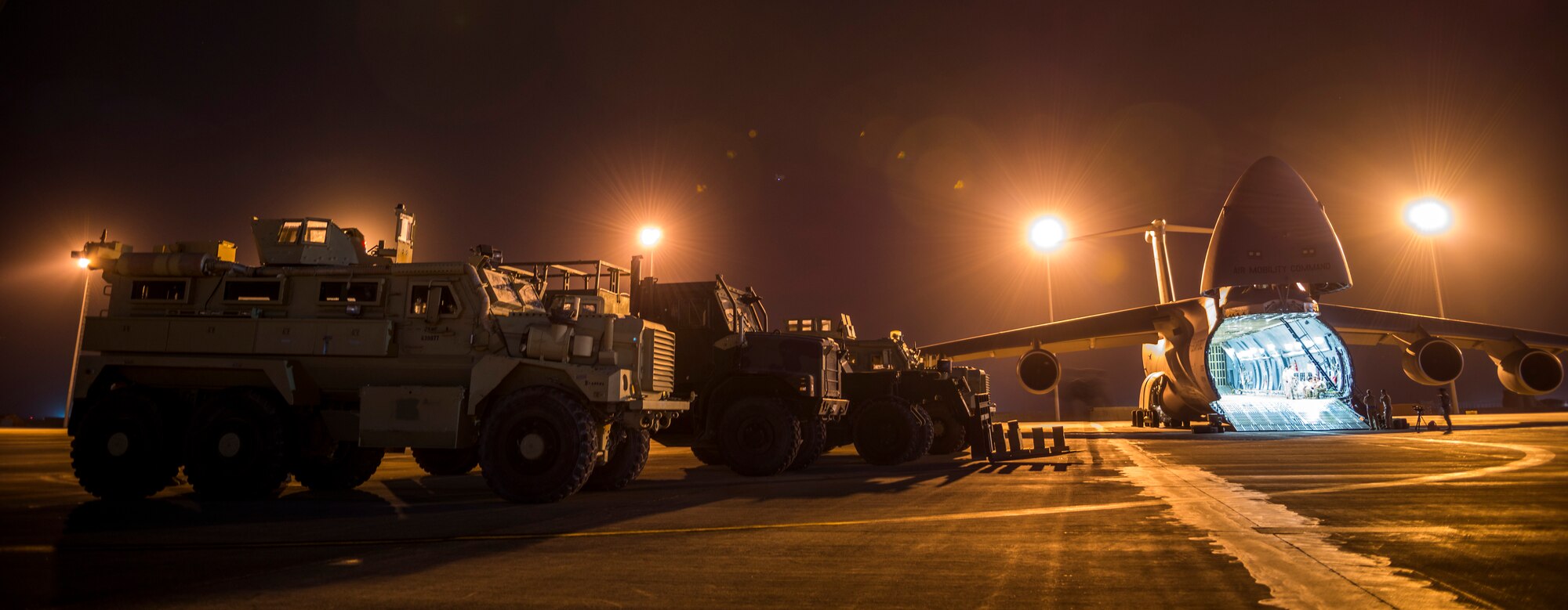 Airmen from the 9th Airlift Squadron and 455th Expeditionary Aerial Port Squadron with Marines from the Marine Expeditionary Brigade prepare to load vehicles into a C-5M Super Galaxy Oct. 6, 2014, at Camp Bastion, Afghanistan. Airmen and Marines loaded more than 266,000 pounds of cargo onto the C-5M as part of retrograde operations in Afghanistan. Aircrews for the retrograde operations, managed by the 385th Air Expeditionary Group Detachment 1, surpassed 11 million pounds of cargo transported in a 50-day period. During this time frame, crews under the 385th AEG broke Air Mobility Command???s operational cargo load record five times. The heaviest load to date is 280,880 pounds. (U.S. Air Force photo by Staff Sgt. Jeremy Bowcock)