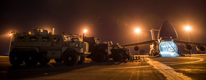Airmen from the 9th Airlift Squadron and 455th Expeditionary Aerial Port Squadron with Marines from the Marine Expeditionary Brigade prepare to load vehicles into a C-5M Super Galaxy Oct. 6, 2014, at Camp Bastion, Afghanistan. Airmen and Marines loaded more than 266,000 pounds of cargo onto the C-5M as part of retrograde operations in Afghanistan. Aircrews for the retrograde operations, managed by the 385th Air Expeditionary Group Detachment 1, surpassed 11 million pounds of cargo transported in a 50-day period. During this time frame, crews under the 385th AEG broke Air Mobility Command's operational cargo load record five times. The heaviest load to date is 280,880 pounds. (U.S. Air Force photo by Staff Sgt. Jeremy Bowcock) 