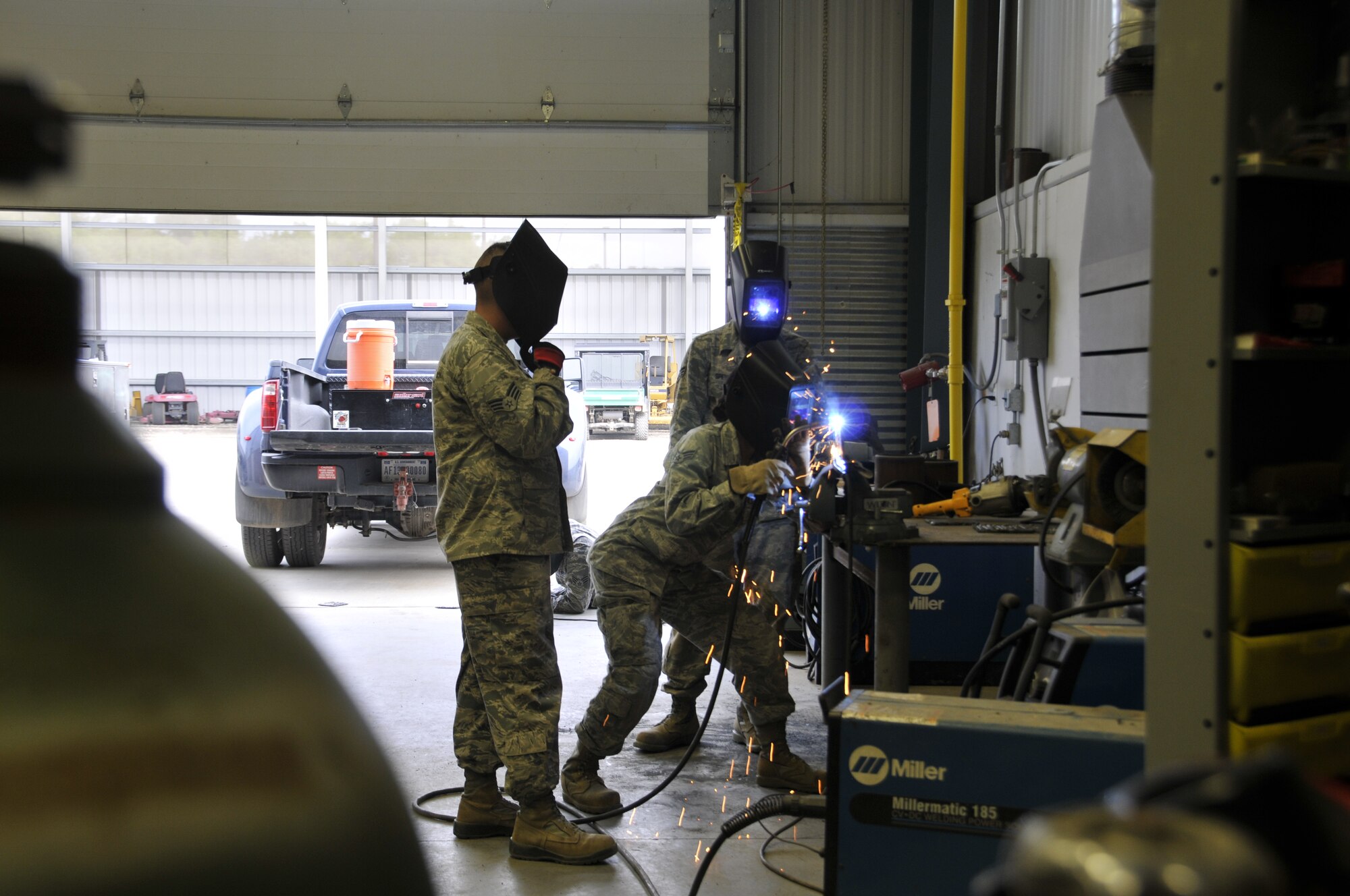 Senior Airman Sarah Greer welds while Senior Airman Christopher Speis and Senior Airman Michael Levison watch during a welding class held at Ebbing Air National Guard Base, Fort Smith, Arkansas Sept. 17, 2014. Six Airmen from the 210th Rapid Engineer Deployable Heavy Operational Repair Squadron Engineer (REDHORSE) Squadron, New Mexico Air National Guard, were trained by the 188th Civil Engineering Squadron led by Tech. Sgt. Bryan Sutton, 188th REDHORSE welding instructor. (U.S. Air National Guard photo by Tech. Sgt. Josh Lewis/Released)