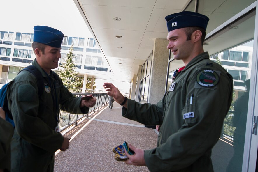 U.S. Air Force Capt. Keith Madsen, 75th Fighter Squadron A-10C Thunderbolt II pilot, trades patches with a cadet from Cadet Squadron 9, Oct. 17, 2014, during a campus tour at the U.S. Air Force Academy, Colo. Following the tour, the 23d Wing highlighted rescue capabilities with a Combat Search and Rescue Task Force demonstration for the Academy’s Cadet Wing. (U.S. Air Force photo by Airman 1st Class Dillian Bamman/Released)