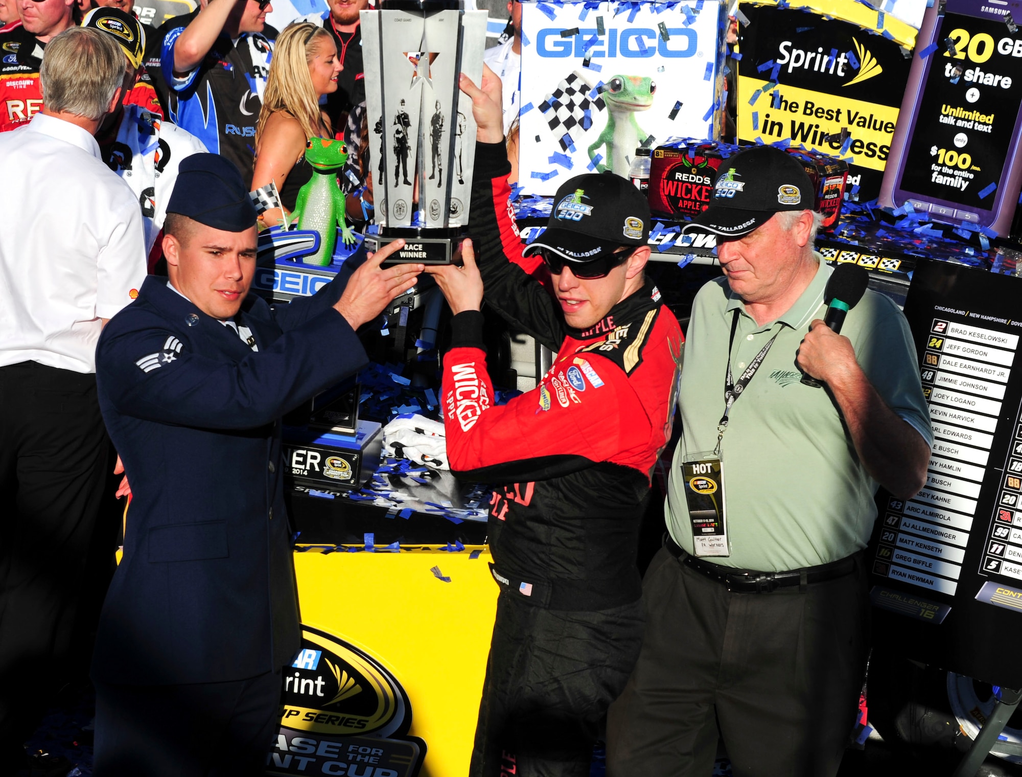 Senior Airman Donald Googe Jr., 42nd Air Base Wing Legal Office paralegal, presents the Freedom Trophy to the Geico 500 winner, Brad Keselowski, at the Talladega Superspeedway in Talladega, Ala., Oct. 19, 2014. The Freedom Trophy showcases the five branches of the military to honor and recognize  military members. (U.S. Air Force photo by Airman 1st Class Alexa Culbert)