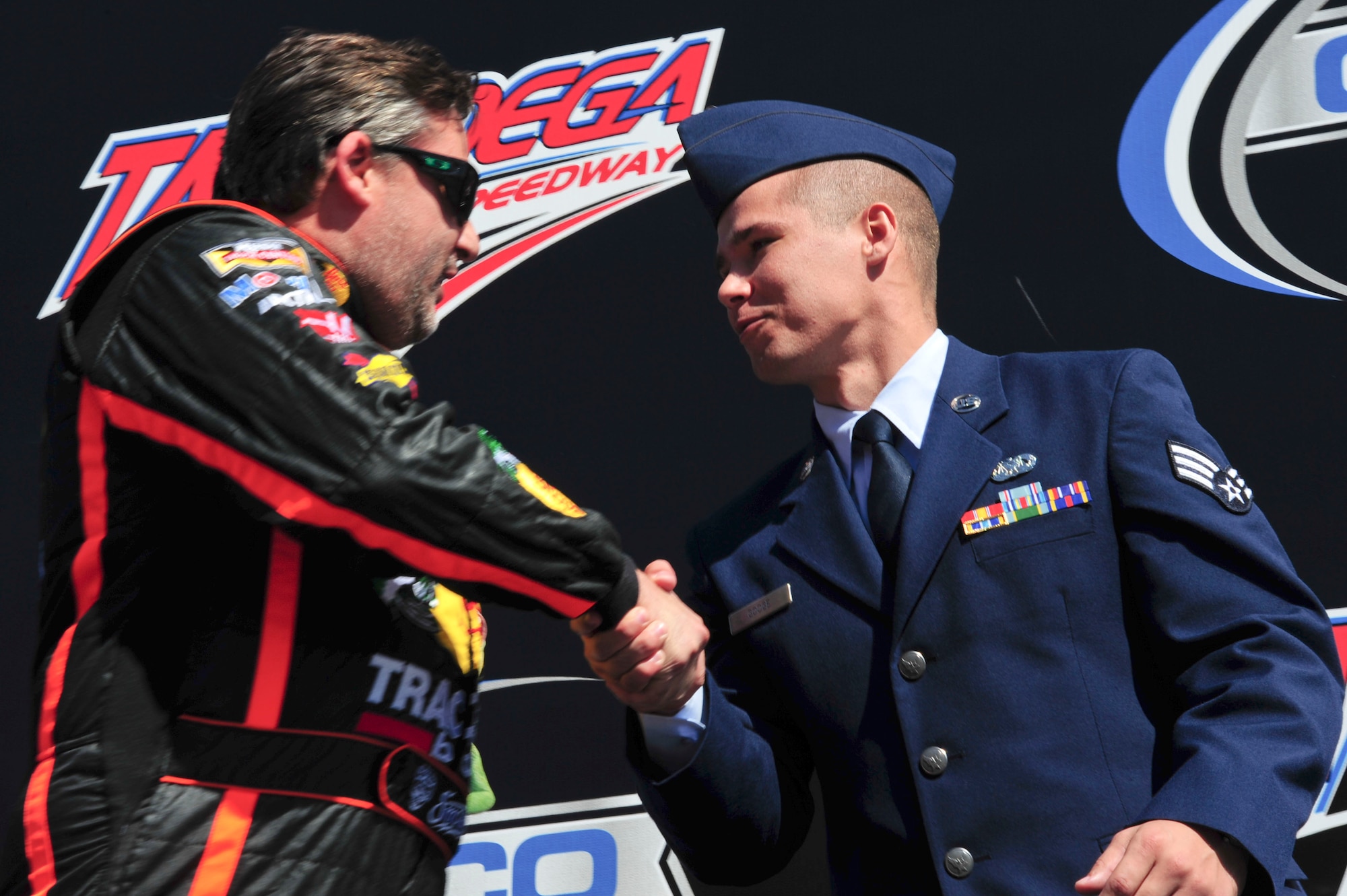 Senior Airman Donald Googe Jr., 42nd Air Base Wing Legal Office paralegal, shakes hands with NASCAR driver Tony Stewart during the Geico 500 Talladega Superspeedway pre-ceremony in Talladega, Ala., Oct. 19, 2014. The ceremony included remarks from special guests and showcased the 43 drivers participating in the race. (U.S. Air Force photo by Airman 1st Class Alexa Culbert) 