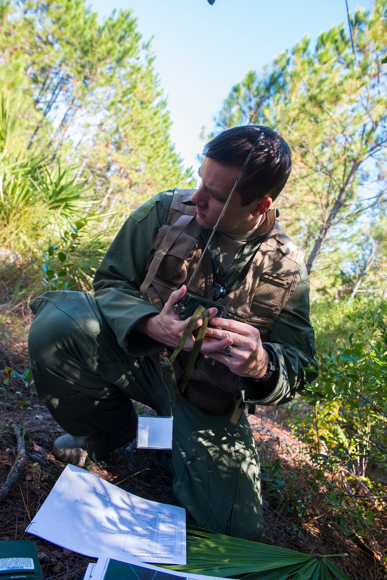 U.S. Air Force Capt. (Dr.) James Mikolajczak, 75th Fighter Squadron flight surgeon, listens to instructions during a combat search and rescue task force exercise Oct. 22, 2014, in Homerville, Ga. Mikolajczak used a radio, map and survival, evasion, resistance and escape training to assist in being saved. (U.S. Air Force Airman 1st  Class Ceaira Tinsley/Released)