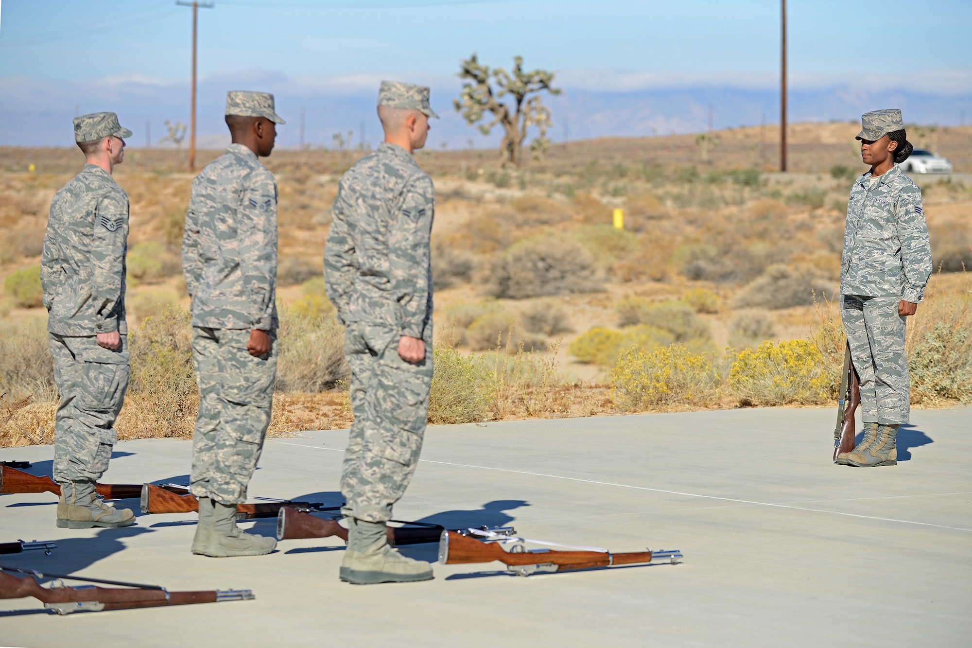 Senior Airman Grace Taylor (right), a U.S. Air Force Honor Guard ceremonial guardsman, demonstrates how to recover a rifle while standing at attention during Firing Party training Oct. 21 on the Airman Leadership School Drill Pad. The eight-day course was intended for more than 22 Blue Eagles Honor Guard members who will graduate from the course on Oct. 29. (U.S. Air Force photo by Jet Fabara)