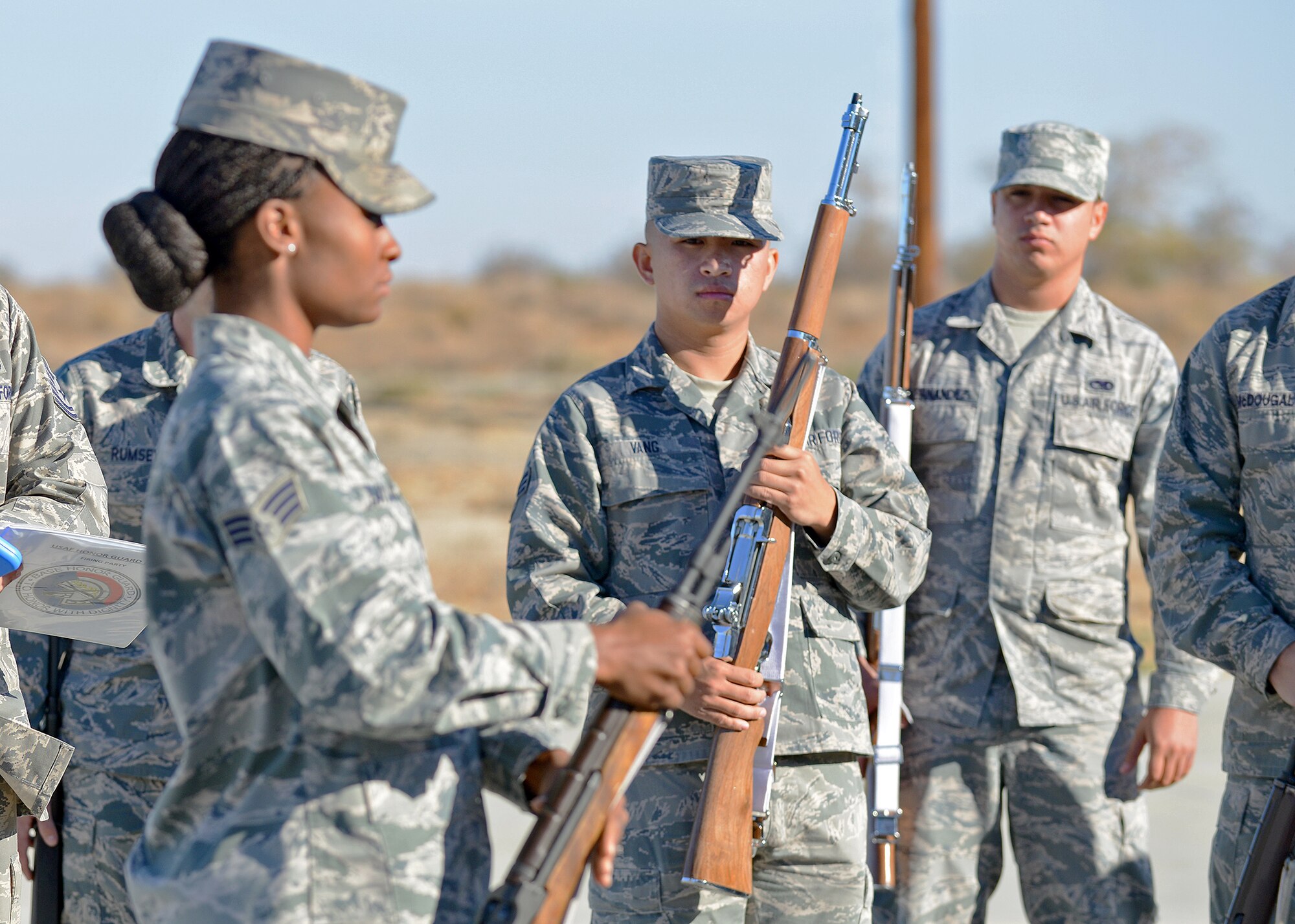 Senior Airman Ernest Vang, from the 412th Communications Squadron, looks on as Senior Airman Grace Taylor, a U.S. Air Force Honor Guard ceremonial guardsman, demonstrates how to stand at attention with a rifle during Firing Party training Oct. 21. The eight-day course was intended for more than 22 Blue Eagles Honor Guard members who will graduate from the course on Oct. 29. (U.S. Air Force photo by Jet Fabara)