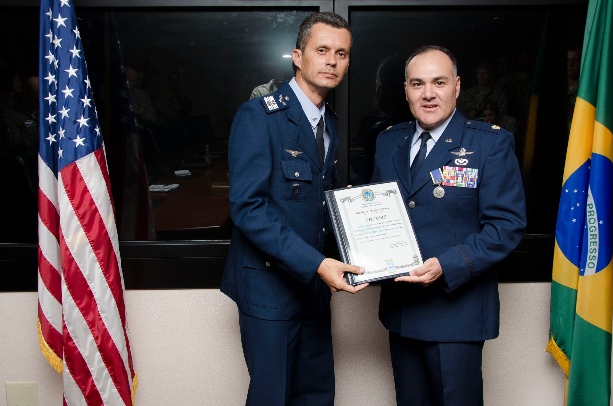 Col Alexandre Alves, Brazilian Air Force Liaison Officer to 12th Air Force (Air Forces Southern) presents Maj. Oscar Parra, 12th Air Force (Air Forces Southern) Regional Affairs Strategist, with the Brazilian Air Force Santos-Dumont Medal before a staff meeting on Oct. 22, 2014 at Davis-Monthan AFB, Ariz. The medal is granted by the commander of the Brazilian Air Force, General Juniti Saito, to individuals who have made valuable contributions to the Brazilian Air Force. Parra’s dedication has directly influenced the success of several bilateral engagements, utilizing his personal and professional knowledge of international relations to move the mission forward; to include working with his leadership in order to advocate for emerging events, not initially available for the Brazilian Air Force. (U.S. Air Force photo by Staff Sgt. Adam Grant/Released)