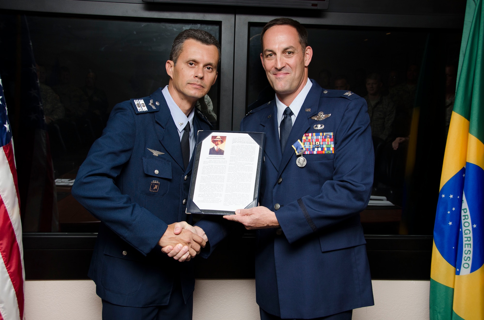 Col Alexandre Alves, Brazilian Air Force Liaison Officer to 12th Air Force (Air Forces Southern) presents Col. Gerald Colmer Jr., 12th Air Force (Air Forces Southern) Air National Guard advisor, with the Brazilian Air Force Santos-Dumont Medal before a staff meeting on Oct. 22, 2014 at Davis-Monthan AFB, Ariz. The medal is granted by the commander of the Brazilian Air Force, General Juniti Saito, to individuals who have made valuable contributions to the Brazilian Air Force. Colmer’s professional perspective of International Affairs and multiple initiatives and solutions have resulted in a better integration between the Brazilian Air Force and the United States Air Force. (U.S. Air Force photo by Staff Sgt. Adam Grant/Released)