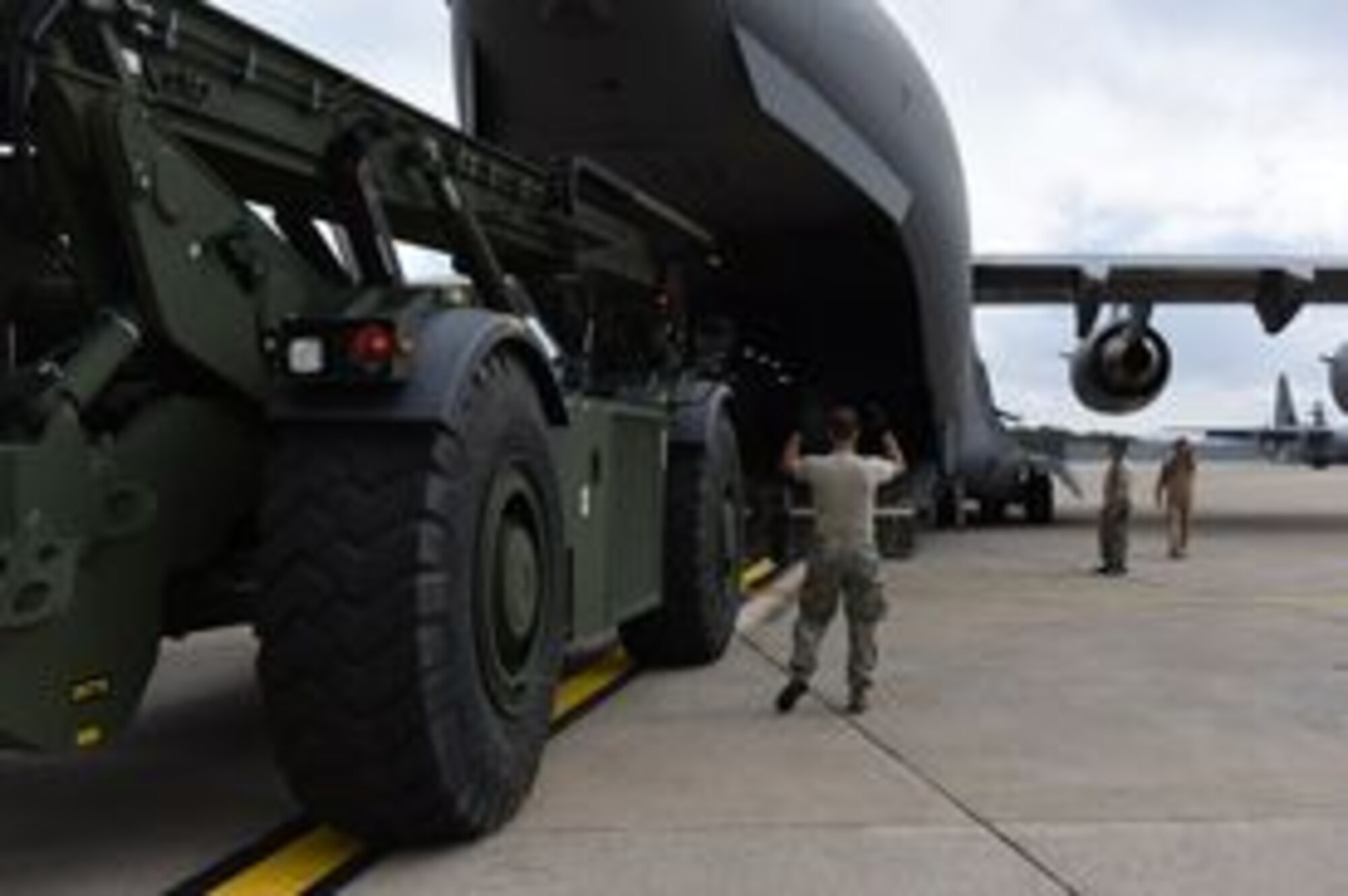 MIDDLETOWN, Pa.  – Employees with the Defense Logistics Agency Distribution Susquehanna, New Cumberland, Pennsylvania and Airmen of the 193rd Special Operations Wing, load a rough terrain container handler onto a C-17 Globemaster III aircraft, Middletown, Pennsylvania, Oct. 16, 2014. The C-17 from the 445th Airlift Wing, Wright-Patterson Air Force Base, Ohio transported the RTCH to Africa in support of the Ebola crisis. (U.S. Air National Guard photo by Tech. Sgt. Culeen Shaffer/Released)