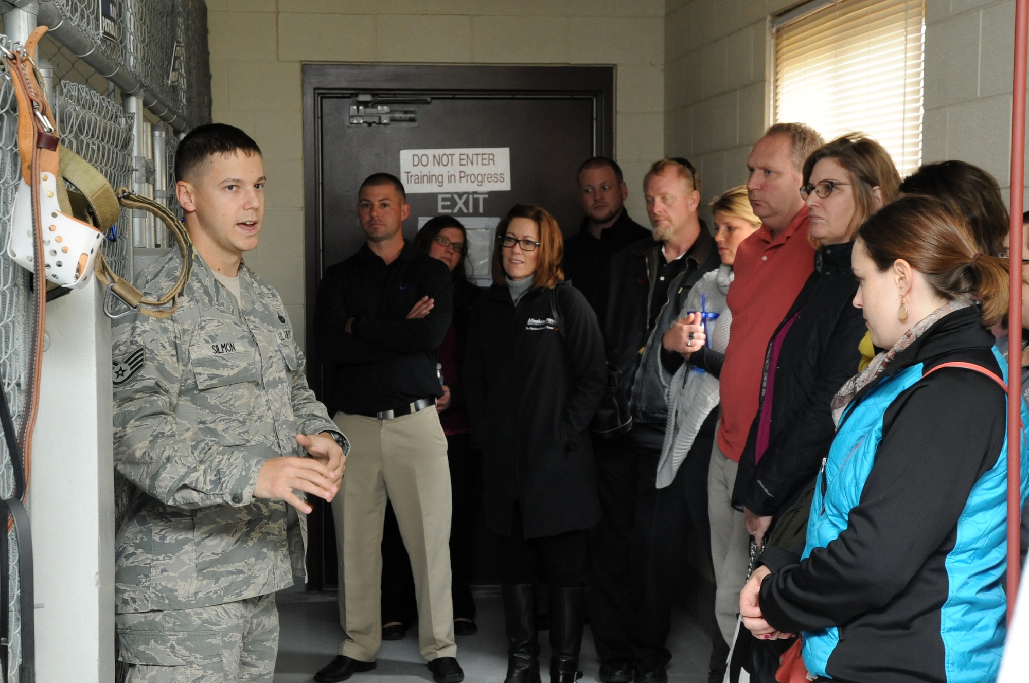 Staff Sgt. Brett Silmon, 319th Security Forces Squadron military working dog handler, gives members of the Grand Forks Chamber of Commerce Annual Leadership Seminar a tour of the MWD kennels on Grand Forks Air Force Base, N.D., Oct. 22, 2014. The group was also treated to a brief demonstration of an Air Force K-9 and handler in training. (U.S. Air Force photo/Staff Sgt. David Dobrydney)
