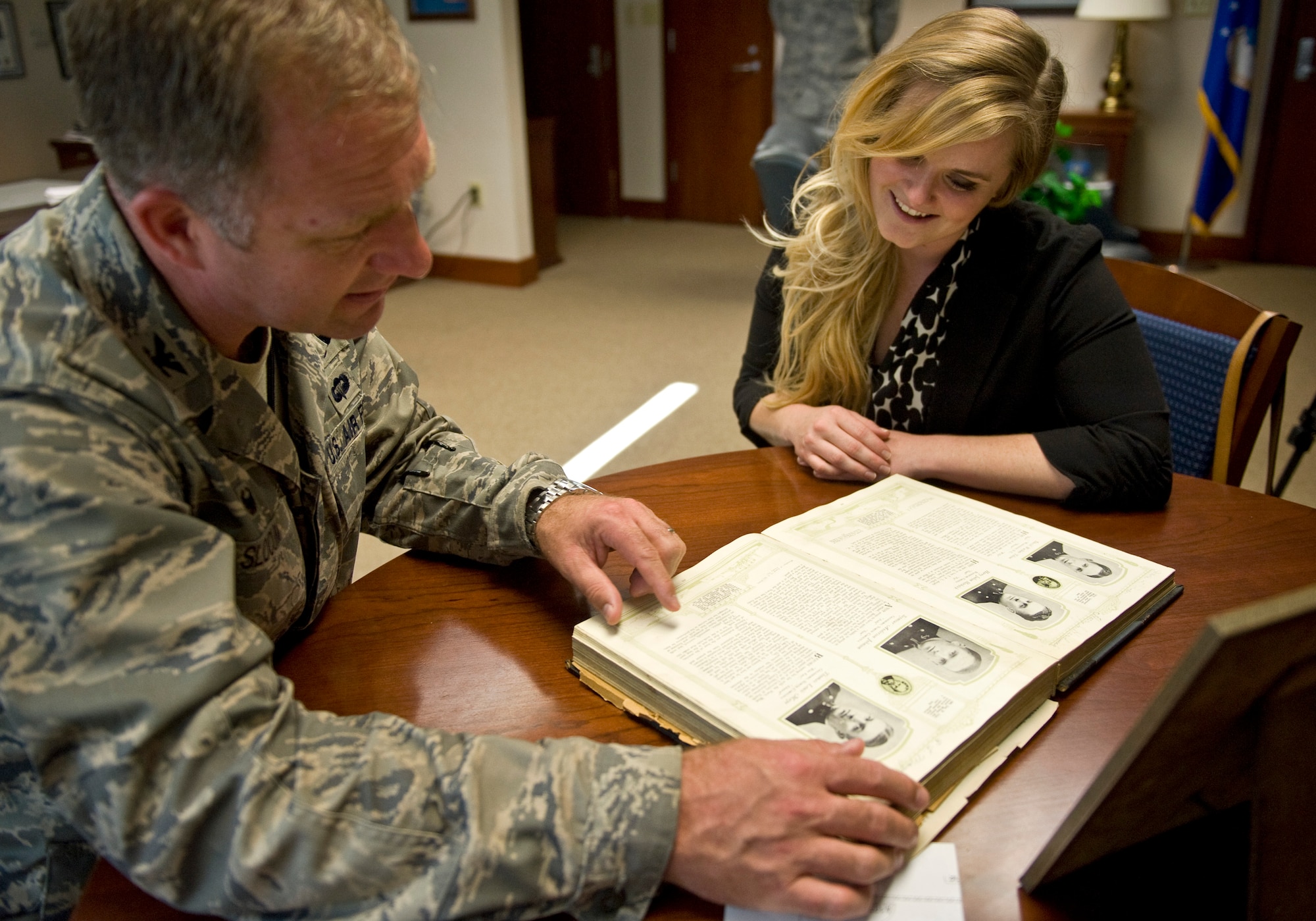 Col. Mark Slocum, 4th Fighter Wing commander, looks at the yearbook of Seymour Johnson Air Force Base’s namesake, U.S. Navy Lt. Seymour Johnson, with Jaime Thompson, Seymour Johnson’s great-granddaughter at Seymour Johnson AFB, North Carolina, Oct. 17, 2014. During her visit, Thompson familiarized herself with Seymour Johnson’s history; both the man and the base. For the first time in her life she was able to discover the full legacy left behind by her great-grandfather. (U.S. Air Force photo/Airman 1st Class Aaron Jenne) 