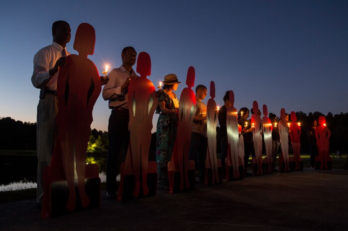 Volunteers hold cardboard references to victims during the Candlelight Vigil at the Municipal Building in Goose Creek, S.C., Oct. 21, 2014. The cutouts were symbols of the victims who have perished due to domestic violence within the last year. The Candlelight Vigil was held in remembrance of the victims of domestic violence in South Carolina. (U.S. Air Force photo/Senior Airman George Goslin)