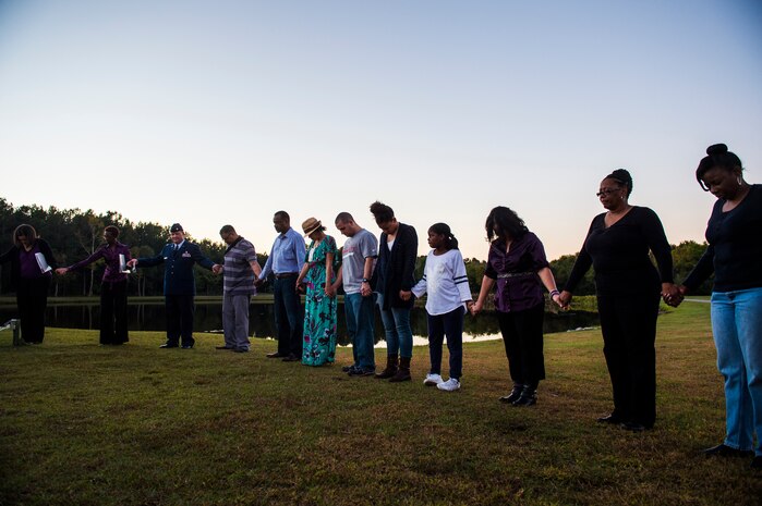 Attendees of the Domestic Violence Candlelight Vigil hold hands at the Municipal Building in Goose Creek, S.C., Oct. 21, 2014. The Candlelight Vigil was held in remembrance of the victims of domestic violence in South Carolina. The event was the second year that JB Charleston was an equal participant in the planning and coordination with the city of Goose Creek. (U.S. Air Force photo/Senior Airman George Goslin)