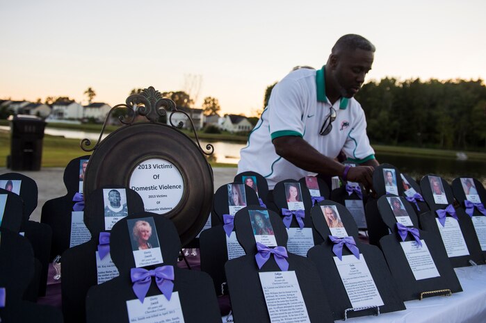Memorial photos are displayed on a table telling the stories of domestic violence victims during the Domestic Violence Candlelight Vigil at the Municipal Building in Goose Creek, S.C., Oct. 21, 2014. The Candlelight Vigil was held in remembrance of the victims of domestic violence in South Carolina. The event was the second year that JB Charleston was an equal participant in the planning and coordination with the city of Goose Creek. (U.S. Air Force photo/Senior Airman George Goslin)