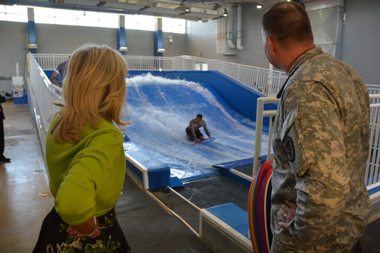 Army Staff Sgt. Angel Perez shows off his boogie boarding skills for Dr. Jill Biden and Col. Don Gajewski, director of the Center for the Intrepid, during Biden’s visit to Brooke Army Medical Center, Oct. 22, 2014. The CFI is BAMC’s outpatient rehabilitation center. U.S. Army photo by Robert Shields