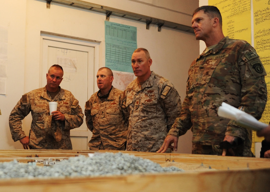 U.S. Navy Chief Petty Officer Samuel Beauchamp, left, Chief Petty Officer Kevin Cassidy, center left, Lt. Cmdr. Jeromy Pittmann, center right, and U.S. Army Col. Peter Andrysiak, far right, listen as Afghan national engineer brigade personnel describe a field training exercise on Camp Ghazi in Kabul, Afghanistan, Oct. 19, 2014. The exercise was the culmination of seven months of training, during which U.S. service members instructed Afghan engineers in vertical and horizontal construction, bridge building, and water well operations. The U.S. sailors are assigned to Naval Mobile Construction Battalion 25. 