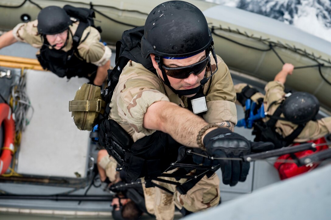 U.S. Navy Petty Officer 1st Class Jeremy Fuzi boards the guided-missile frigate USS Rodney M. Davis from a rigid-hull inflatable boat while conducting a visit, board, search and seizure exercise in the Indian Ocean, Oct. 21, 2014. 