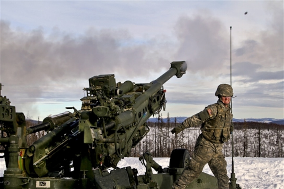 Army Pfc. Alexander Ivie fires a howitzer during a field artillery walk and shoot in Alaska, Oct. 11, 2014. Ivie is a howitzer crew member assigned to 2nd Battalion, 8th Field Artillery Regiment. 
