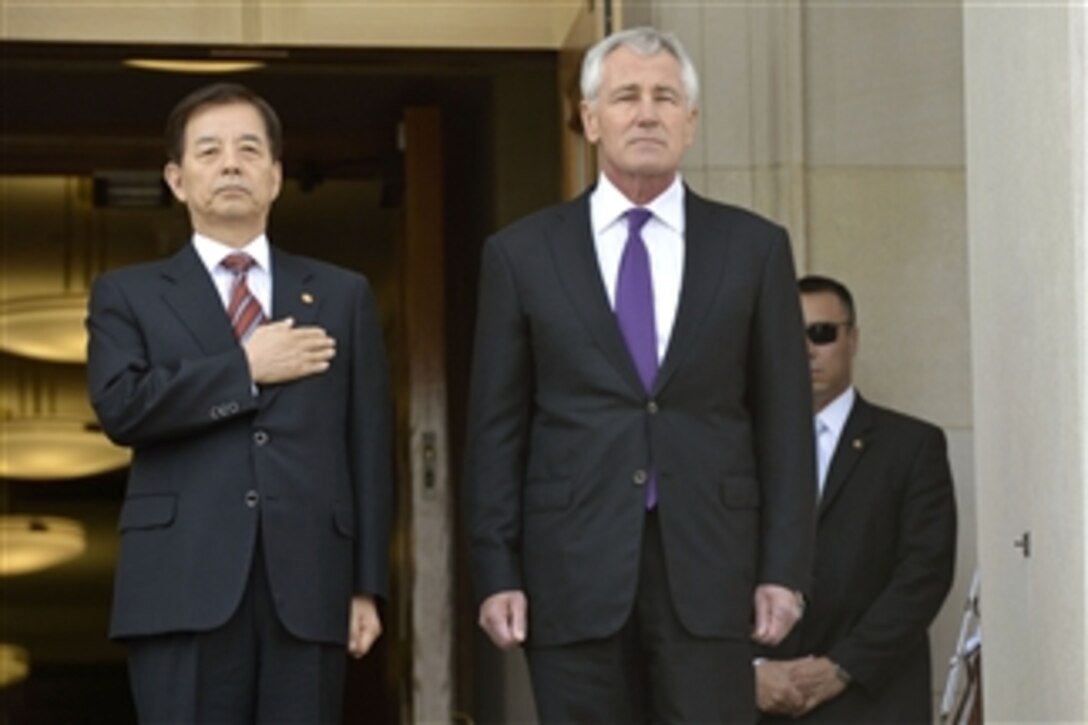 U.S. Defense Secretary Chuck Hagel, right, and South Korean Defense Minister Han Min-koo stand as a military band plays the national anthems of both countries at the Pentagon, Oct. 23, 2014. Hagel welcomed his counterpart for a meeting to discuss matters of mutual importance.