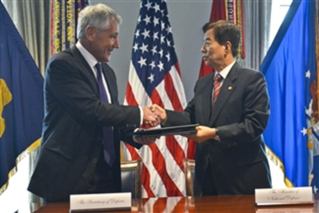 U.S. Defense Secretary Chuck Hagel, left, and South Korean Defense Minister Han Min-koo shake hands after signing a memorandum of understanding at the Pentagon, Oct. 23, 2014. 