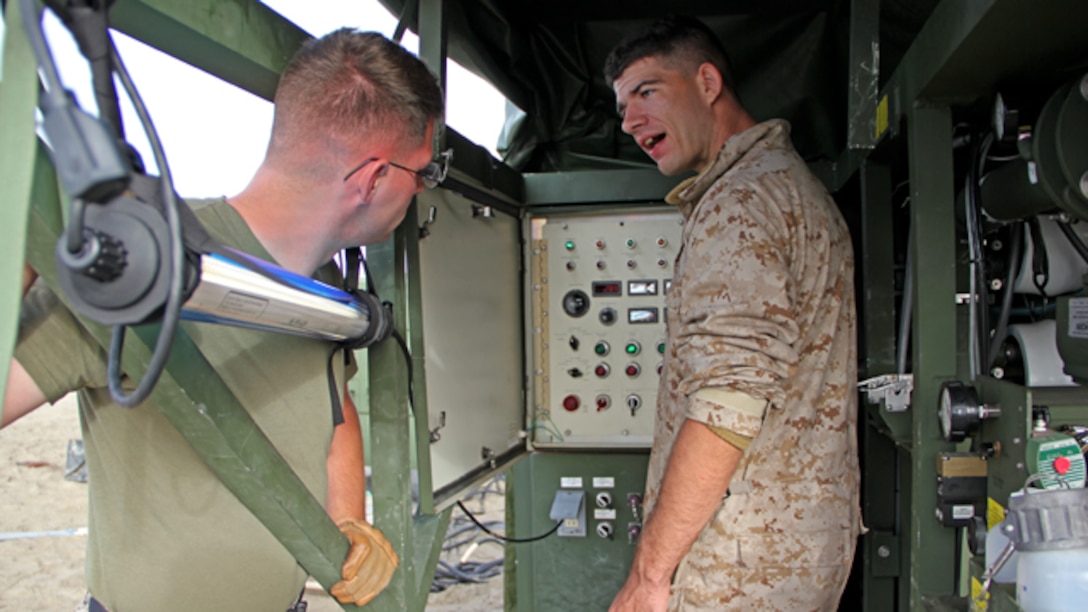 Lance Cpl. Anthony Andes, right, a water support technician with Marine Wing Support Squadron 373, explains the gages of the Tactical Water Purification System at Marine Corps Base Camp Pendleton during exercise Pacific Horizon 2015, Oct. 23. PH 15 increases the ability of 1st Marine Expeditionary Brigade and Expeditionary Strike Group 3 to plan, communicate and conduct complex sea and shore based operations in response to natural disasters. (U.S. Marine Corps photo by Lance Cpl. Caitlin Bevel)