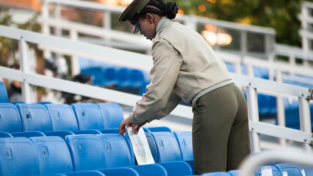 A Marine with Marine Barracks, Washington D.C. tapes a placard to a seat for the Passing of Command ceremony Oct. 17, 2014. Gen. James F. Amos, the 35th commandant of the Marine Corps, passed the battle colors to Gen. Joseph F. Dunford, Jr., 36th commandant of the Marine Corps. The battle colors signify the change of authority for America’s premiere fighting force.
