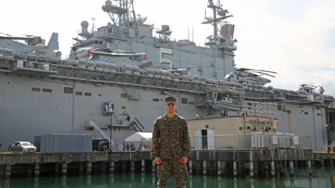 Marine Corps 1st Lt. Sy Poggemeyer stands in front of the USS Peleliu (LHA-5) in port, Oct. 21, 2014. Poggemeyer’s stepfather, Navy Capt. Michael Krieger, served on the USS Peleliu 20 years ago, the same ship that Poggemeyer is currently deployed on with the 31st Marine Expeditionary Unit. The 31st MEU/Peleliu Amphibious Ready Group recently participated in Amphibious Landing Exercise 15 in the Philippines as part of a regularly-scheduled Fall Patrol of the Asia-Pacific region.