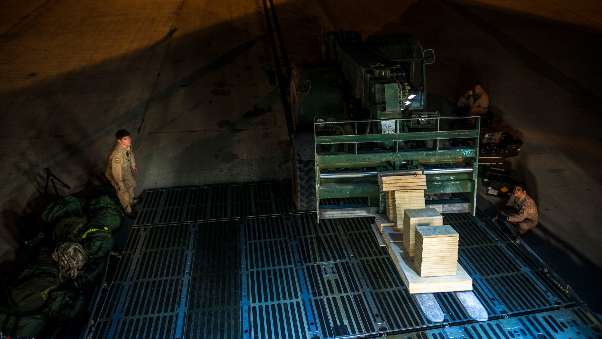 Airmen from the 9th Airlift Squadron and 455th Expeditionary Aerial Port Squadron with Marines from the Marine Expeditionary Brigade prepare to load vehicles into a C-5M Super Galaxy Oct. 6, 2014, at Camp Bastion, Afghanistan. Airmen and Marines loaded more than 266,000 pounds of cargo onto the C-5M as part of retrograde operations in Afghanistan. Aircrews for the retrograde operations, managed by the 385th Air Expeditionary Group Detachment 1, surpassed 11 million pounds of cargo transported in a 50-day period. During this time frame, crews under the 385th AEG broke Air Mobility Command’s operational cargo load record five times. The heaviest load to date is 280,880 pounds. (U.S. Air Force photo by Staff Sgt. Jeremy Bowcock)