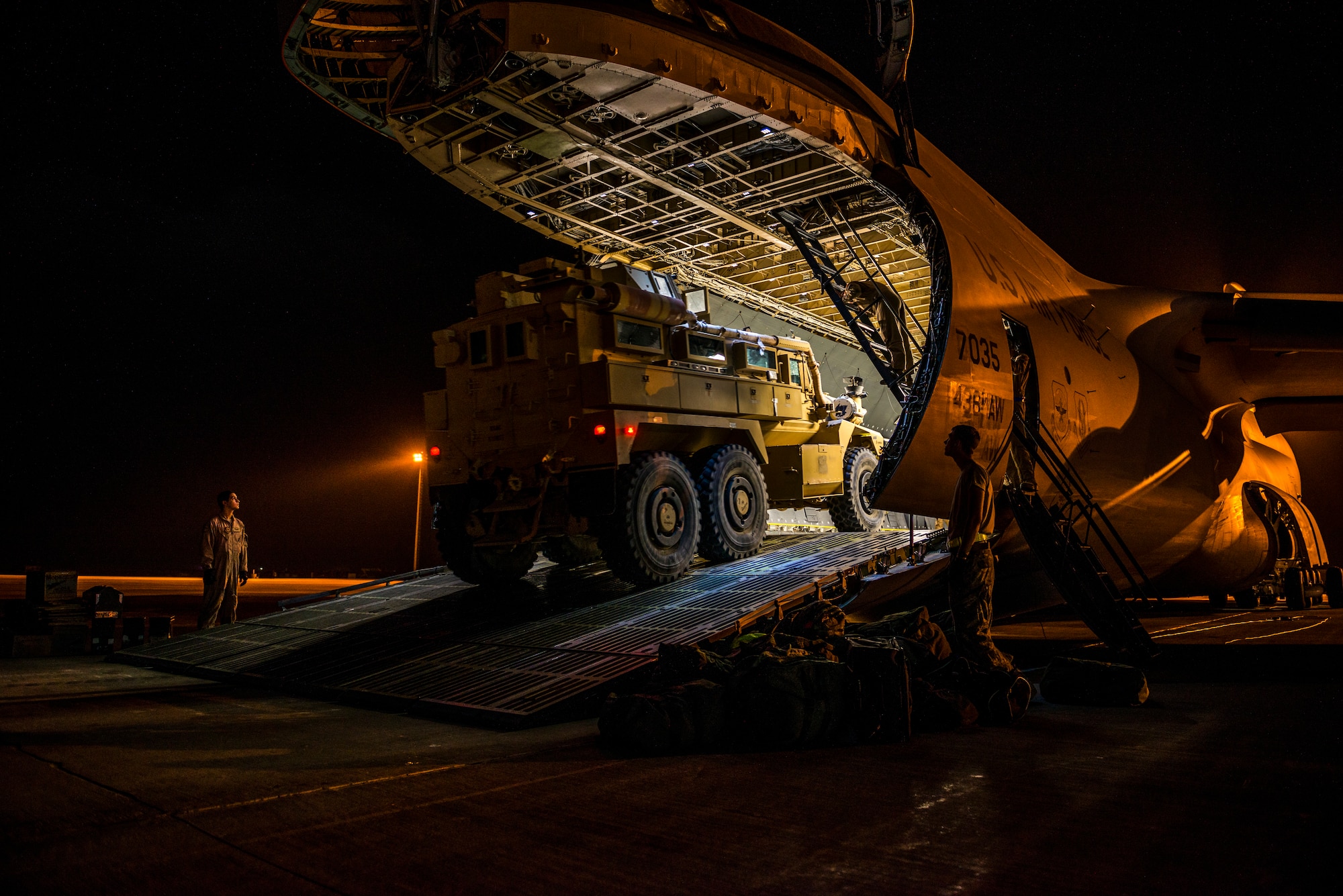 Airmen from the 9th Airlift Squadron and 455th Expeditionary Aerial Port Squadron with Marines from the Marine Expeditionary Brigade prepare to load vehicles into a C-5M Super Galaxy Oct. 6, 2014, at Camp Bastion, Afghanistan. Airmen and Marines loaded more than 266,000 pounds of cargo onto the C-5M as part of retrograde operations in Afghanistan. Aircrews for the retrograde operations, managed by the 385th Air Expeditionary Group Detachment 1, surpassed 11 million pounds of cargo transported in a 50-day period. During this time frame, crews under the 385th AEG broke Air Mobility Command’s operational cargo load record five times. The heaviest load to date is 280,880 pounds. (U.S. Air Force photo by Staff Sgt. Jeremy Bowcock)