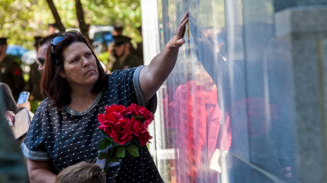 A guest during the 31st Beirut Memorial Observance touches the name of a fallen loved one after the ceremony at the Beirut Memorial, Jacksonville, N.C., Oct. 23, 2014. Each year, a memorial observance takes place on October 23rd to remember those lives lost at the Beirut barracks bombing in Beirut, Lebanon. (U.S. Marine Corps photo by Cpl. Carolyn P. Pichardo, MCI-East Combat Camera/Released)