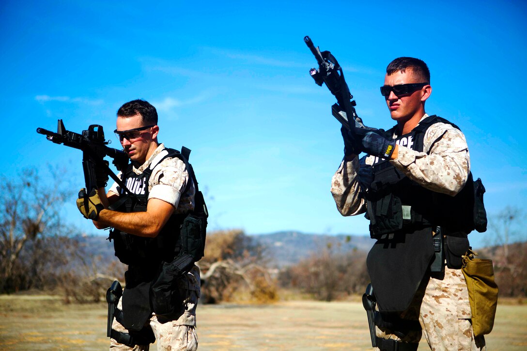 CAMP PENDLETON, Calif. - Lance Cpl. Kevin Dooling and Lance Cpl. Justin Mullen, members of the Provost Marshall Office's Special Reaction Team, conduct tactical reloads prior to a live-fire training evolution at Range 300, Oct. 23.  The SRT is responsible for any critical situations that fall beyond the capabilities of ordinary law enforcement. (U.S. Marine Corps photo by Cpl. Keenan Zelazoski)