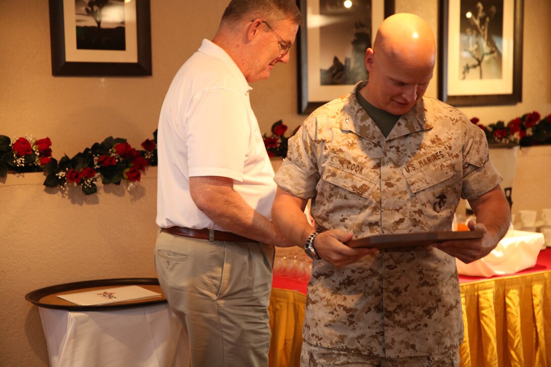 Col. Matt Cook, commanding officer, Marine Corps Logistics Operations Group, looks at the award MCLOG received for achieving one hundred percent contact for donation during last year’s campaign at the Combined Federal Campaign Kickoff Breakfast hosted in the Officers’ Club, Oct.15, 2014. (Photo/Pfc. Thomas Mudd)