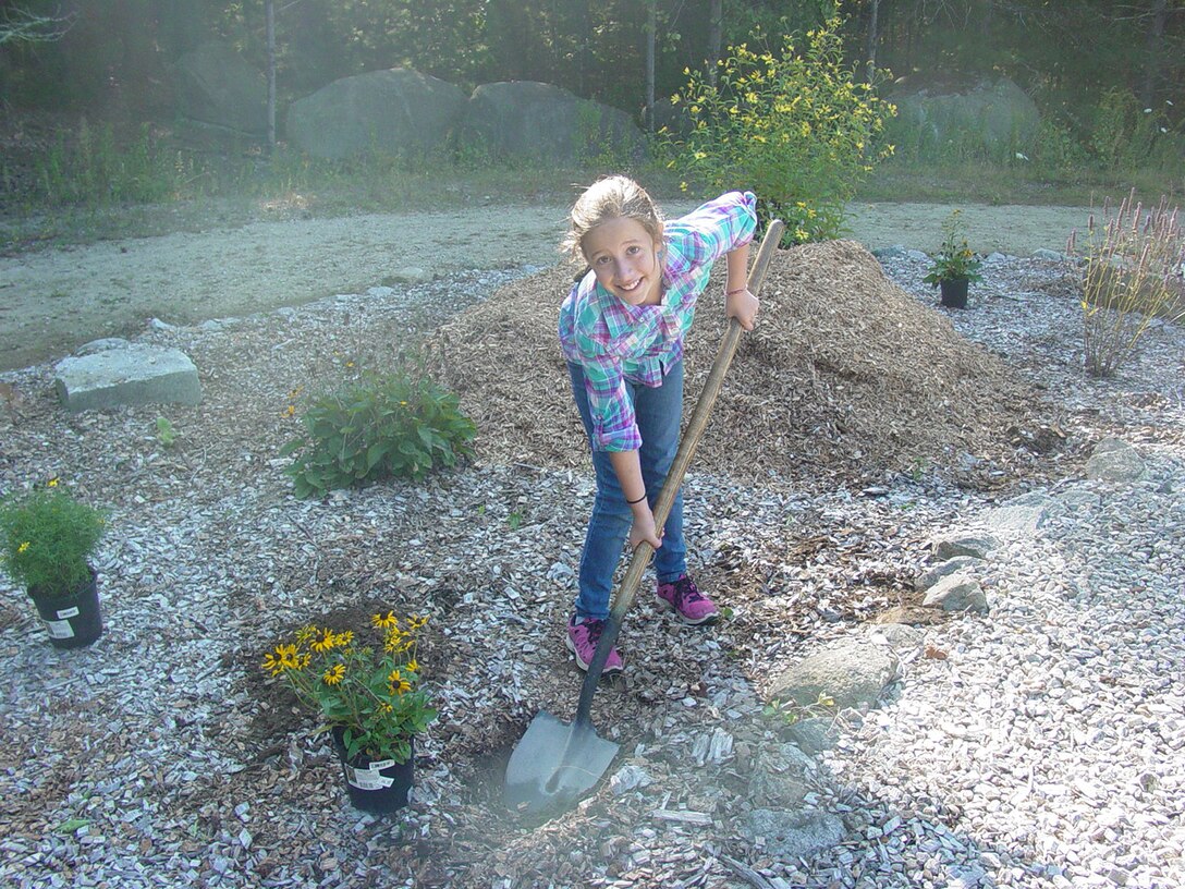 A volunteer plants flowers at West Hill Dam, Uxbridge, Mass., during a National Public Lands Day event on Sept. 20, 2014.