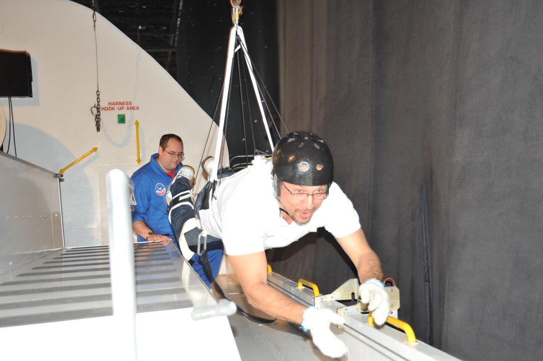 U.S. Space & Rocket Center crew trainer Chris Gorman supervises as Alfonso Santa, an architect with the Operations and Maintenance Medical Engineering Enhancement division under the U.S. Army Engineering and Support Center, Huntsville's Engineering Directorate, simulates weightlessness as he travels along the bay of a space shuttle mock-up and the U.S. Space & Rocket Center during the Center's Leadership Development Program II exercise during a Space Camp corporate camp wich provides training and development programs tailored to achieve the objectives LDP II.