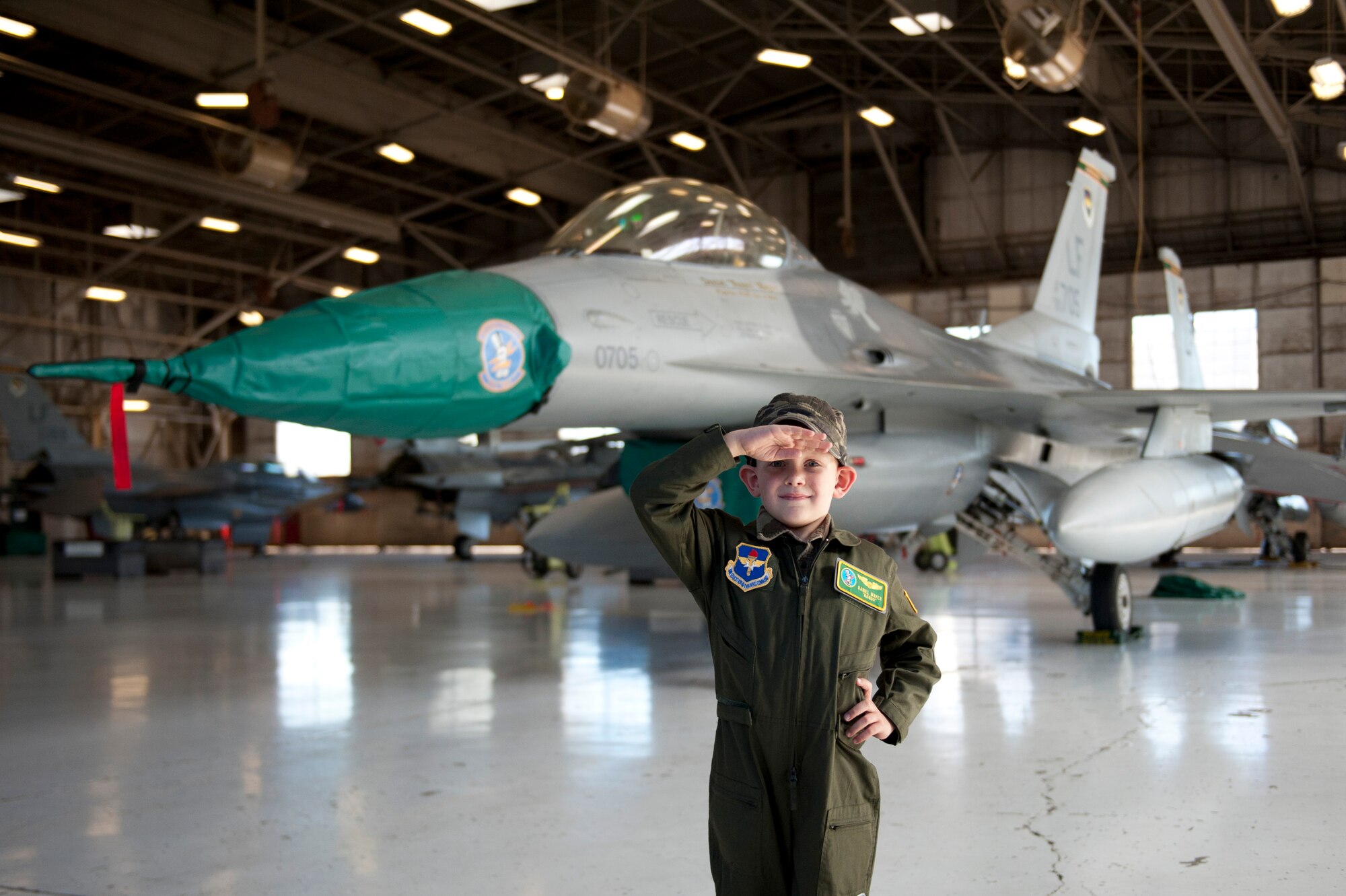 Daniel "Nanoo" Mayer, pilot for a day, salutes in front of an F-16 Fighting Falcon at the 310th Fighter Squadron on Luke Air Force Base, Arizona, Oct. 24, 2014. The pilot for a day program focuses on children who have serious or chronic conditions and invites them to be a part of a flying squadron for an entire day. Mayer was diagnosed with Acute Lymphoblastic Leukemia two years ago and is currently in remission. (U.S. Air Force photo by Staff Sgt. Staci Miller)
