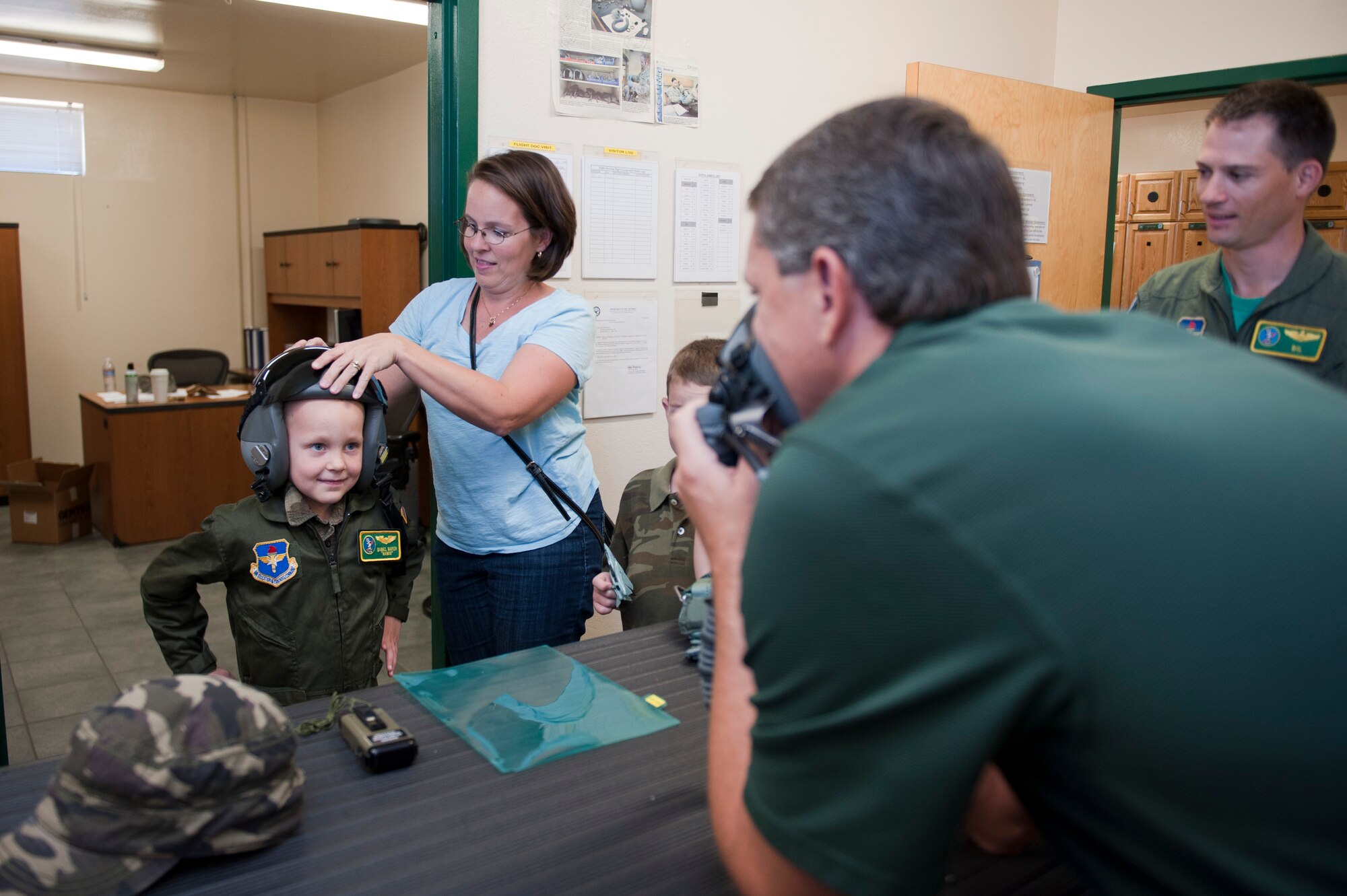 Daniel "Nanoo" Mayer, pilot for a day, tries on a flight helmet at the 310th Fighter Squadron on Luke Air Force Base, Arizona, Oct. 24, 2014. The pilot for a day program focuses on children who have serious or chronic conditions and invites them to be a part of a flying squadron for an entire day. Mayer was diagnosed with Acute Lymphoblastic Leukemia two years ago and is currently in remission. (U.S. Air Force photo by Staff Sgt. Staci Miller)