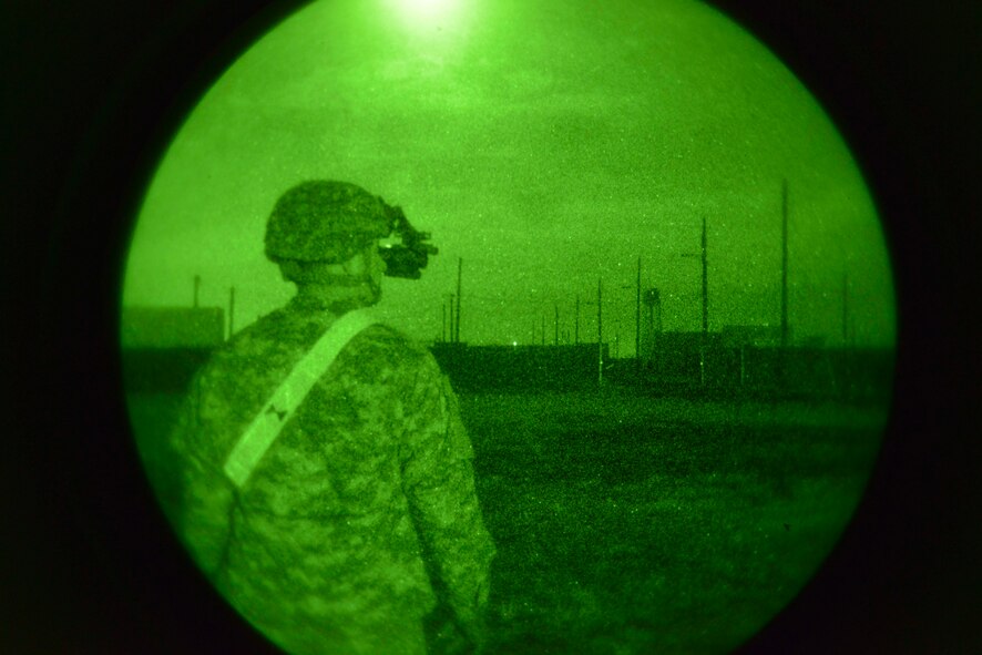 An inspector from the 2nd Battalion, 75th Ranger Regiment stationed at Joint Base Lewis-McChord, Wash., supervises a joint exercise as Army Rangers advance to their objective on the flightline Oct. 15, 2014, at Fairchild Air Force Base, Wash. (U.S. Air Force photo/Airman 1st Class Janelle Patiño)