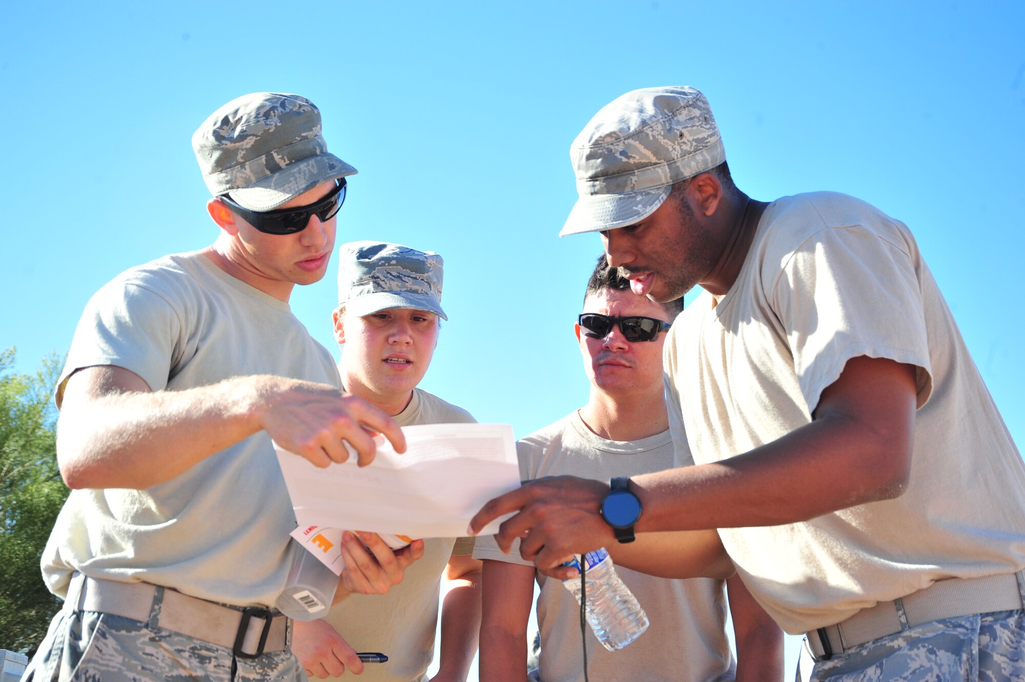 Team members work together to complete a worksheet during a competition held at Davis-Monthan Air Force Base, Ariz., Oct. 23, 2014.  This station required each team to match symptoms of chemical exposure to the chemical agent responsible.  (U.S. Air Force Photo by Airman 1st Class Chris Massey/Released)